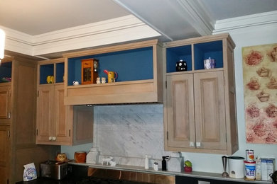 Example of an eclectic galley dark wood floor eat-in kitchen design in Providence with beaded inset cabinets, medium tone wood cabinets, soapstone countertops, white backsplash, stainless steel appliances and a peninsula