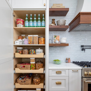 Foto di una grande cucina costiera con lavello stile country, ante grigie, top in marmo, paraspruzzi blu, paraspruzzi con piastrelle di vetro, elettrodomestici da incasso, pavimento in legno massello medio, isola, pavimento marrone e top bianco
