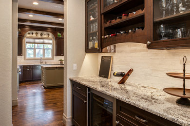 Example of a large trendy u-shaped medium tone wood floor eat-in kitchen design in Denver with an undermount sink, shaker cabinets, dark wood cabinets, granite countertops, beige backsplash, glass tile backsplash, stainless steel appliances and two islands