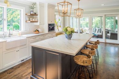 Large transitional l-shaped dark wood floor enclosed kitchen photo in Chicago with recessed-panel cabinets, white cabinets, marble countertops, white backsplash, subway tile backsplash, stainless steel appliances and an island