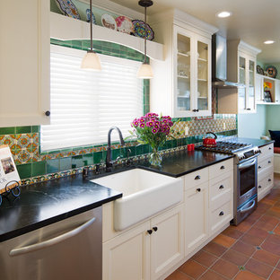 Mid-sized craftsman eat-in kitchen ideas - Inspiration for a mid-sized craftsman single-wall terra-cotta tile eat-in kitchen remodel in San Diego with a farmhouse sink, recessed-panel cabinets, white cabinets, soapstone countertops, green backsplash, ceramic backsplash and stainless steel appliances