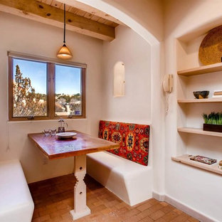Small l-shaped separate kitchen in Albuquerque with a double-bowl sink, granite benchtops, black splashback, ceramic splashback, black appliances, brick floors and no island.