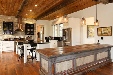 Large farmhouse u-shaped medium tone wood floor eat-in kitchen photo in Austin with shaker cabinets, stainless steel appliances, white cabinets, an undermount sink, gray backsplash, stone tile backsplash, soapstone countertops and an island