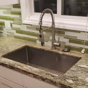 This is an example of a mid-sized contemporary kitchen in Los Angeles with a single-bowl sink, white cabinets, granite benchtops, green splashback and green benchtop.