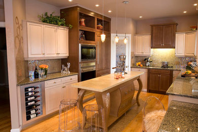 Eat-in kitchen - mid-sized eclectic u-shaped medium tone wood floor and beige floor eat-in kitchen idea in Calgary with a double-bowl sink, raised-panel cabinets, distressed cabinets, quartz countertops, multicolored backsplash, stainless steel appliances, mosaic tile backsplash and an island