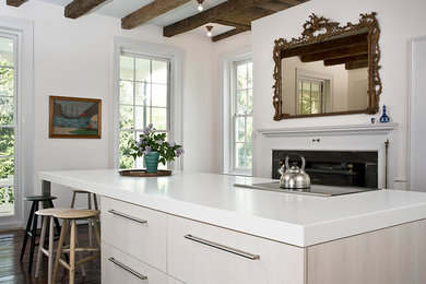 This is an example of a large traditional l-shaped kitchen/diner in New York with flat-panel cabinets, white cabinets, engineered stone countertops, dark hardwood flooring, an island and brown floors.