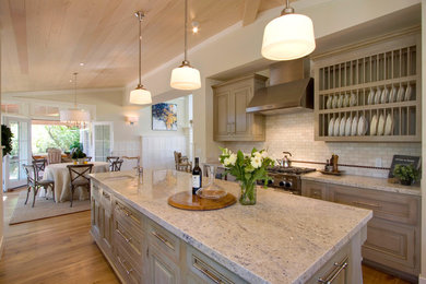 Inspiration for a large transitional l-shaped medium tone wood floor eat-in kitchen remodel in San Francisco with a single-bowl sink, raised-panel cabinets, beige cabinets, marble countertops, white backsplash, subway tile backsplash, stainless steel appliances and an island