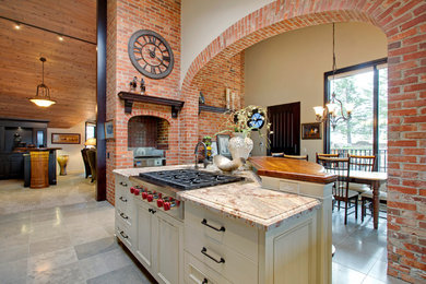 Klassisk inredning av ett mellanstort kök, med en undermonterad diskho, luckor med upphöjd panel, skåp i mörkt trä, granitbänkskiva, brunt stänkskydd, stänkskydd i stickkakel, rostfria vitvaror, klinkergolv i keramik, en köksö och beiget golv