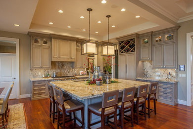 Exempel på ett stort modernt kök, med en undermonterad diskho, luckor med infälld panel, grå skåp, granitbänkskiva, beige stänkskydd, stänkskydd i sten, integrerade vitvaror, mörkt trägolv och en köksö