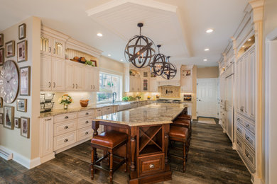 Example of a large french country u-shaped vinyl floor and brown floor eat-in kitchen design in Other with a farmhouse sink, raised-panel cabinets, light wood cabinets, granite countertops, beige backsplash, terra-cotta backsplash, stainless steel appliances, an island and beige countertops