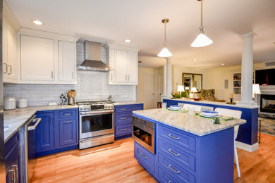 Inspiration for a mid-sized transitional l-shaped medium tone wood floor and brown floor open concept kitchen remodel in Boston with an undermount sink, recessed-panel cabinets, blue cabinets, marble countertops, gray backsplash, subway tile backsplash, stainless steel appliances, an island and gray countertops