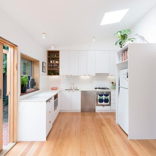 Kleine Skandinavische Küche mit weißen Schränken, Arbeitsplatte aus Terrazzo, Küchenrückwand in Weiß, Rückwand aus Keramikfliesen, hellem Holzboden und weißer Arbeitsplatte in Melbourne