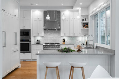 Eat-in kitchen - mid-sized contemporary l-shaped light wood floor and brown floor eat-in kitchen idea in Vancouver with an undermount sink, shaker cabinets, white cabinets, quartz countertops, white backsplash, marble backsplash, stainless steel appliances, a peninsula and gray countertops