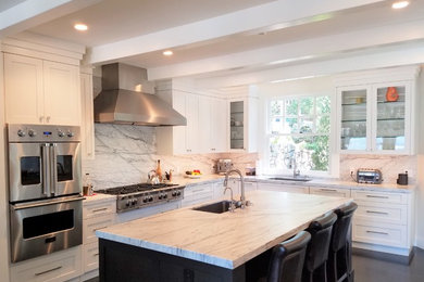 L-shaped kitchen photo in San Francisco with marble countertops and an island
