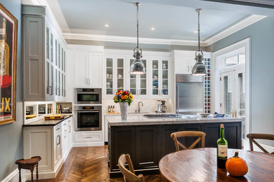 Example of a classic eat-in kitchen design in Philadelphia with shaker cabinets, white cabinets, granite countertops, stainless steel appliances and white backsplash