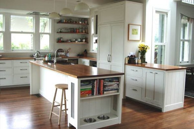 オークランドにある高級な広いトラディショナルスタイルのおしゃれなキッチン (エプロンフロントシンク、落し込みパネル扉のキャビネット、白いキャビネット、木材カウンター、シルバーの調理設備、無垢フローリング) の写真