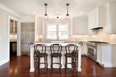 Large transitional l-shaped medium tone wood floor eat-in kitchen photo in Minneapolis with a farmhouse sink, flat-panel cabinets, white cabinets, marble countertops, white backsplash, ceramic backsplash, stainless steel appliances and an island