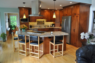 Eat-in kitchen - traditional l-shaped light wood floor eat-in kitchen idea in Philadelphia with a double-bowl sink, shaker cabinets, medium tone wood cabinets, beige backsplash, ceramic backsplash, stainless steel appliances and an island