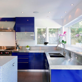 This is an example of a large contemporary l-shaped open plan kitchen in Ottawa with an integrated sink, flat-panel cabinets, blue cabinets, quartz benchtops, white splashback, stainless steel appliances, porcelain floors and with island.