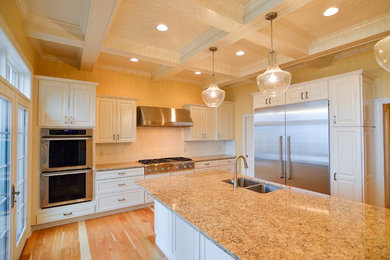 Eat-in kitchen - traditional light wood floor eat-in kitchen idea in Cleveland with a double-bowl sink, raised-panel cabinets, white cabinets, quartz countertops, white backsplash, ceramic backsplash, stainless steel appliances and an island