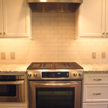 Stainless Steel Stove and Hood with Subway Tile Backsplash