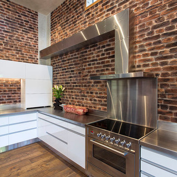 Stainless steel, white joinery and exposed brick in harmony