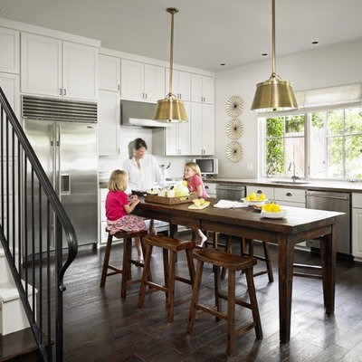 Inspiration for a timeless l-shaped kitchen remodel in Austin with stainless steel appliances, concrete countertops, white cabinets and white backsplash