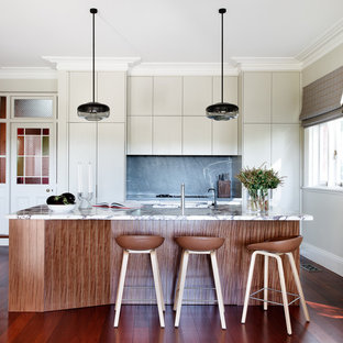 Eclectic galley eat-in kitchen in Sydney with an undermount sink, flat-panel cabinets, marble benchtops, grey splashback, stone slab splashback, stainless steel appliances, medium hardwood floors, with island, brown floor, multi-coloured benchtop and beige cabinets.