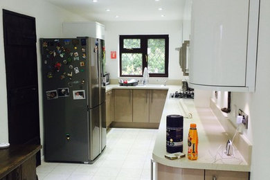 Photo of a medium sized contemporary l-shaped enclosed kitchen in Kent with ceramic flooring and no island.