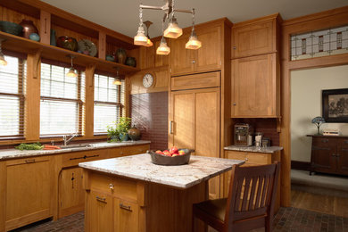 Diseño de cocina de estilo americano con fregadero bajoencimera, armarios estilo shaker, puertas de armario de madera oscura, electrodomésticos con paneles, suelo de ladrillo y una isla