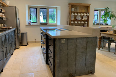 グロスタシャーにある広いコンテンポラリースタイルのおしゃれなキッチン (ヴィンテージ仕上げキャビネット、コンクリートカウンター、グレーのキッチンパネル、黒い調理設備、ベージュの床、グレーのキッチンカウンター) の写真