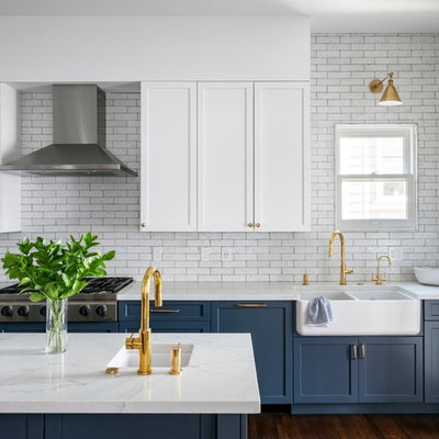 Kitchen - transitional brown floor and dark wood floor kitchen idea in San Francisco with a farmhouse sink, quartz countertops, white backsplash, stainless steel appliances, an island, white countertops, shaker cabinets, blue cabinets and subway tile backsplash