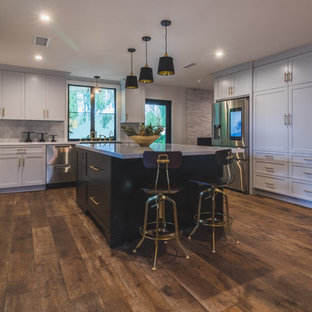 Farmhouse kitchen designs - Example of a farmhouse u-shaped dark wood floor and brown floor kitchen design in Los Angeles with shaker cabinets, gray cabinets, gray backsplash, stainless steel appliances, an island and white countertops