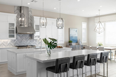 Inspiration for a transitional porcelain tile and gray floor kitchen remodel in San Diego with an undermount sink, shaker cabinets, white cabinets, quartz countertops, gray backsplash, porcelain backsplash, stainless steel appliances, two islands and white countertops