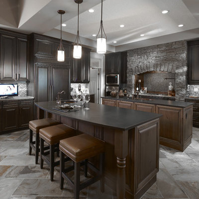 Example of a classic kitchen design in Calgary with raised-panel cabinets, dark wood cabinets, gray backsplash and paneled appliances