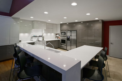 Foto på ett mellanstort funkis kök, med en undermonterad diskho, släta luckor, vita skåp, bänkskiva i kvarts, vitt stänkskydd, rostfria vitvaror och en köksö
