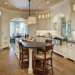 Idee per una cucina classica di medie dimensioni con lavello stile country, ante in stile shaker, ante bianche, paraspruzzi bianco, pavimento in legno massello medio, isola, top in marmo, paraspruzzi con piastrelle in ceramica e elettrodomestici in acciaio inossidabile