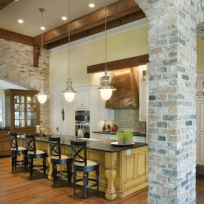 Inspiration for a timeless galley medium tone wood floor and brown floor kitchen remodel in Nashville with mosaic tile backsplash, a farmhouse sink, raised-panel cabinets, white cabinets, multicolored backsplash, stainless steel appliances and an island