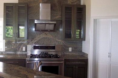 Example of a mid-sized transitional l-shaped travertine floor and beige floor open concept kitchen design in Hawaii with an undermount sink, recessed-panel cabinets, brown cabinets, granite countertops, brown backsplash, stone slab backsplash, stainless steel appliances, an island and brown countertops
