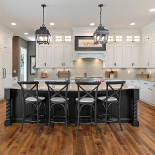 Large traditional kitchen designs - Example of a large classic medium tone wood floor kitchen design in Cincinnati with white cabinets, granite countertops, gray backsplash, subway tile backsplash, stainless steel appliances, an island, raised-panel cabinets and gray countertops
