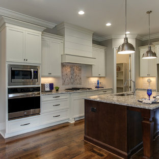 Mid-sized transitional kitchen remodeling - Mid-sized transitional l-shaped medium tone wood floor kitchen photo in Raleigh with a single-bowl sink, recessed-panel cabinets, white cabinets, granite countertops, white backsplash, ceramic backsplash, stainless steel appliances and an island