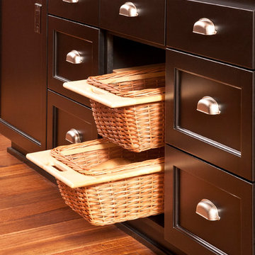 Storage basket drawers in custom cabinetry island with butcher block counter
