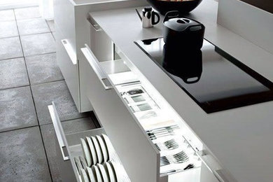 Esempio di una grande cucina minimalista con lavello integrato, ante lisce, ante bianche, top in superficie solida, pavimento in cementine e pavimento grigio