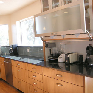 This is an example of a large transitional l-shaped eat-in kitchen in Albuquerque with an undermount sink, flat-panel cabinets, medium wood cabinets, quartz benchtops, green splashback, glass tile splashback, stainless steel appliances, dark hardwood floors and no island.