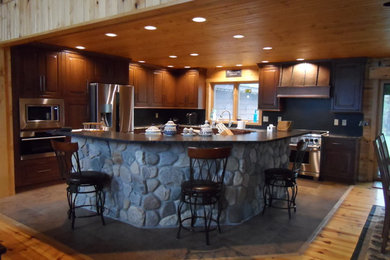 Large mountain style l-shaped ceramic tile and brown floor open concept kitchen photo in Other with an undermount sink, beaded inset cabinets, gray cabinets, quartz countertops, black backsplash, stainless steel appliances and an island