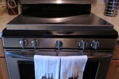 Imagen de cocina comedor lineal minimalista de tamaño medio con electrodomésticos de acero inoxidable