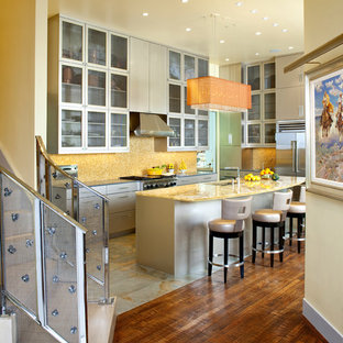 Inspiration pour une grand cuisine américaine parallèle design avec un placard à porte plane, un électroménager en acier inoxydable, un évier 2 bacs, des portes de placard grises, un plan de travail en surface solide, une crédence jaune, une crédence en mosaïque, un sol en ardoise, un îlot central et un plan de travail jaune.