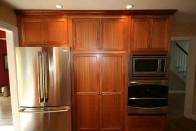Diseño de cocina tradicional con armarios con rebordes decorativos, puertas de armario de madera en tonos medios y encimera de granito