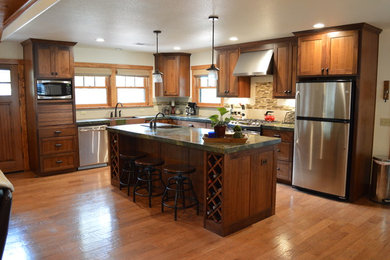 Inspiration for a mid-sized craftsman l-shaped medium tone wood floor and brown floor open concept kitchen remodel in Sacramento with a farmhouse sink, shaker cabinets, dark wood cabinets, granite countertops, stainless steel appliances, an island, beige backsplash and matchstick tile backsplash