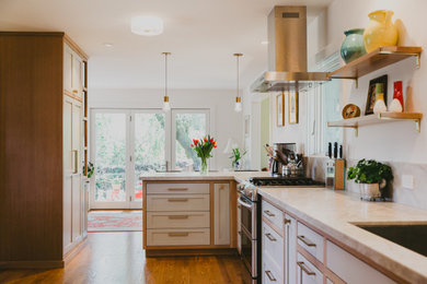 Imagen de cocina moderna grande cerrada con fregadero de un seno, armarios estilo shaker, puertas de armario de madera clara, salpicadero beige, electrodomésticos de acero inoxidable, suelo de madera en tonos medios, península y encimeras beige